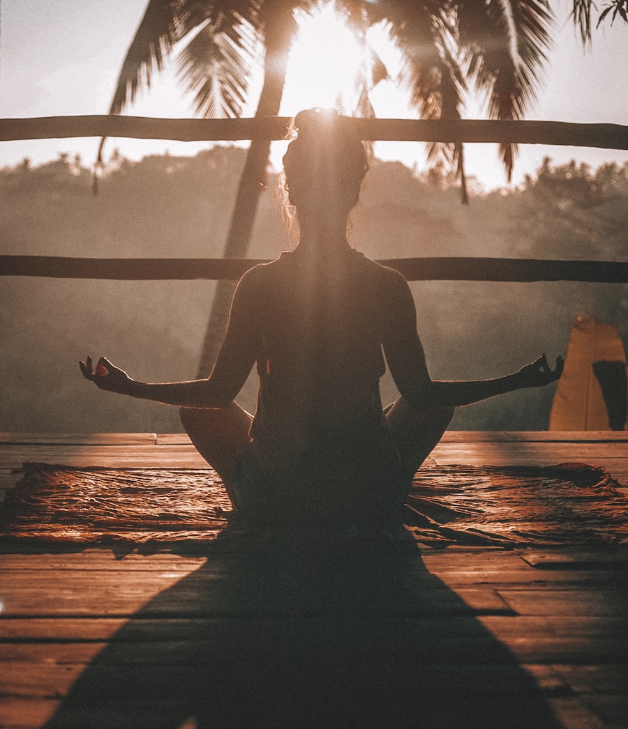 A person sitting calmly in meditation at sunrise